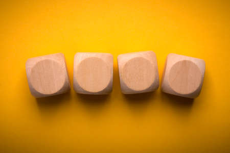 Four blank wooden blocks isolated on color background.