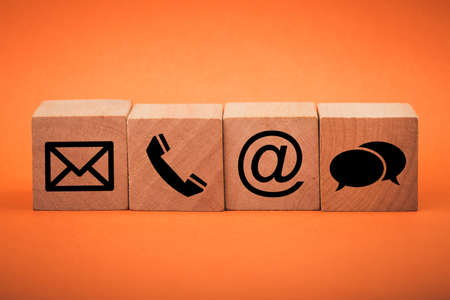 Contact Methods. Close-up of a phone, email, chat and post icons wooden block.の写真素材