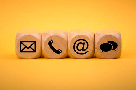 Contact Methods. Close-up of a phone, email, chat and post icons wooden block.の写真素材