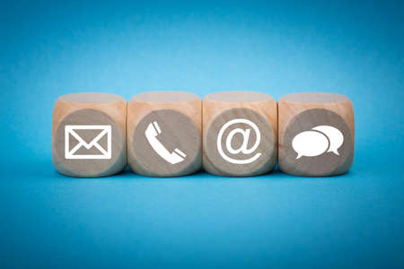 Contact Methods. Close-up of a phone, email, chat and post icons wooden block.の写真素材