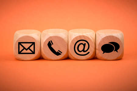 Contact Methods. Close-up of a phone, email, chat and post icons wooden block.の写真素材