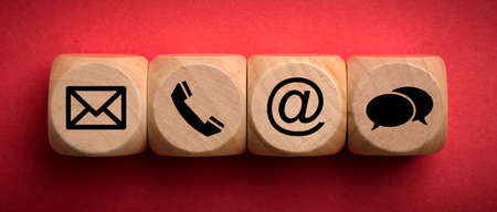 Contact Methods. Close-up of a phone, email, chat and post icons wooden block.の写真素材
