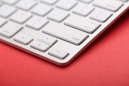 Closeup Shot Of White Keyboard on red background.の写真素材