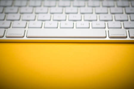 Closeup Shot Of White Keyboard on yellow background.の写真素材