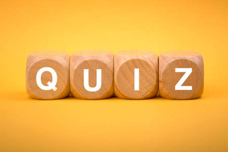 Quiz concept wooden blocks isolated on yellow background.の写真素材