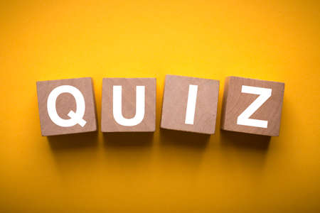 Quiz concept wooden blocks isolated on yellow background.の写真素材