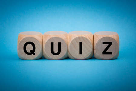Quiz concept wooden blocks isolated on blue background.の写真素材
