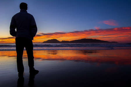 Men on the beach in the sunriseの写真素材