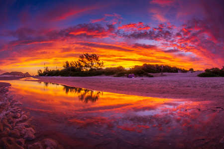 Sunset with orange and red clouds over Campeche beach in Florian?polis Brazilの写真素材