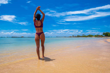 Girl in bikini stretching on the beach at Morro de Sao Paulo in Bahia Brazilの写真素材