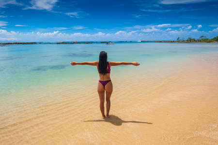Girl with arms wide open feeling blessed on the beachの写真素材