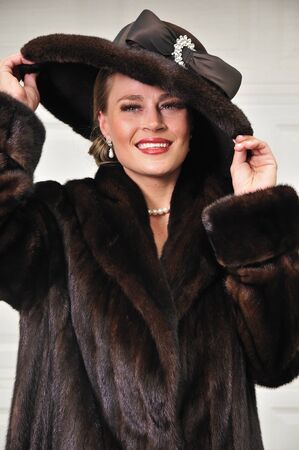 High class modern woman dressed in luxurious fur coat and fur hatの写真素材