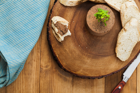 Homemade pate in round shape on a slice of tree trunkの写真素材