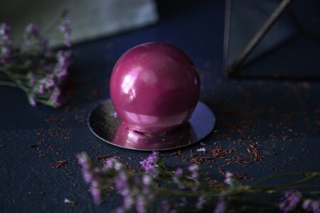 Delicious posh chocolate ball dessert on dark background with flowers