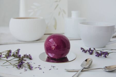 Violet chocolate ball delicious dessert on white background with flowersの写真素材