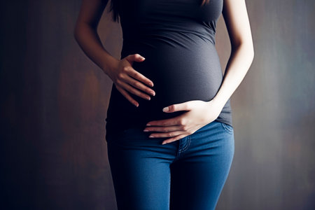 close-up of pregnant woman touching her belly. Pregnancy health and wellbeing concept.の素材