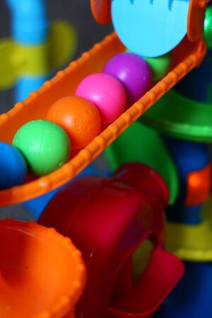 a row of rainbow colored balls is lined up on a children's activity toyの写真素材