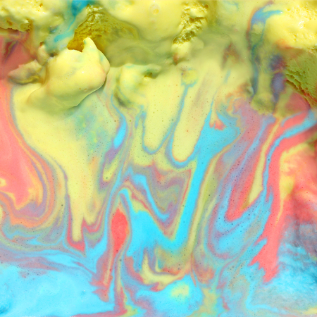 a close up square background of melted pink, blue, and yellow rainbow sorbet ice cream on a hot summer dayの写真素材