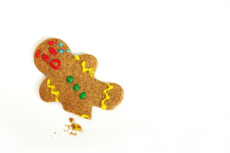 a Christmas Gingerbread Cookie man is upset because someone has eaten his leg, and crumbs are left behind on an isolated white backgroundの写真素材