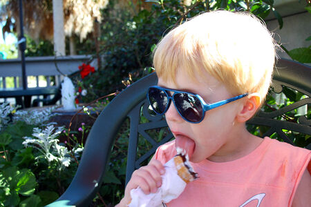 Child Eating Ice Cream Cone Outsideの写真素材