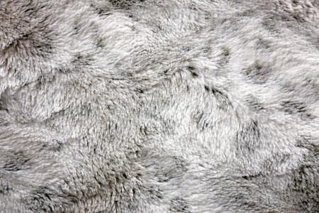 Close up on a background of soft and fuzzy, white and grey, shag faux fur blanket material.