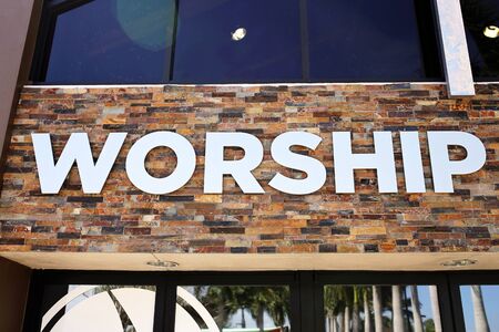 The Word Worship is written on the outside of a large religious Christian church building.の写真素材