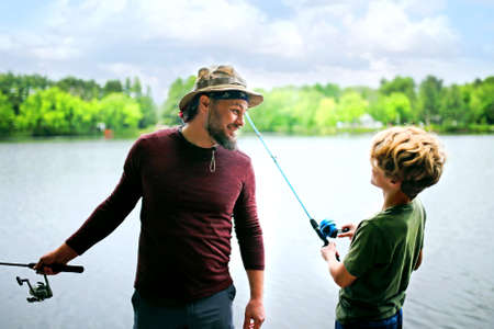 Happy Father and his Son Outside Fishing on Lake on Summer Day