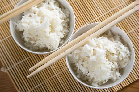 Two bowls of basmati white rice with wooden chopsticksの写真素材