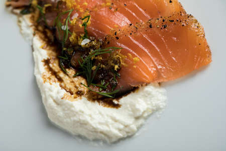 Smoked salmon sashimi slices with horseradish cr?me fraiche dip, dill, lemon zest and soy sauce as an appetizer or amuse gueule in gourmet restaurantの写真素材