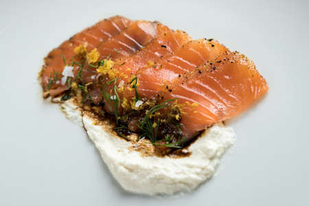 Smoked salmon sashimi slices with horseradish cr?me fraiche dip, dill, lemon zest and soy sauce as an appetizer or amuse gueule in gourmet restaurantの写真素材