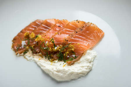 Smoked salmon sashimi slices with horseradish creme fraiche sauce, dill, lemon zest as an appetizer or amuse gueule in gourmet restaurantの写真素材