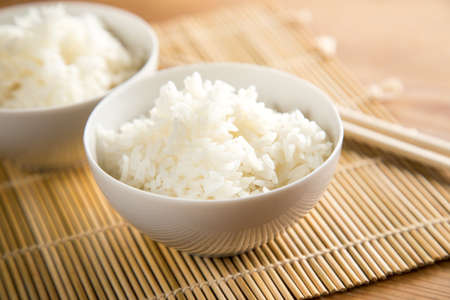 Two bowls of basmati white rice with wooden chopsticksの写真素材