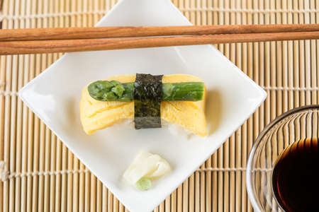 Japanese Tamago omelette nigiri sushi with green asparagus and soy sauceの写真素材