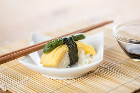 Japanese Tamago omelette nigiri sushi with green asparagus and soy sauceの写真素材
