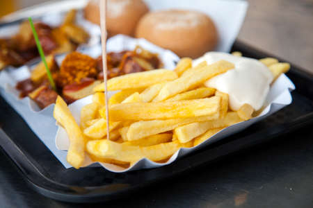 German Currywurst sausage with curry sauce, french fries and mayonnaise on food marketの写真素材