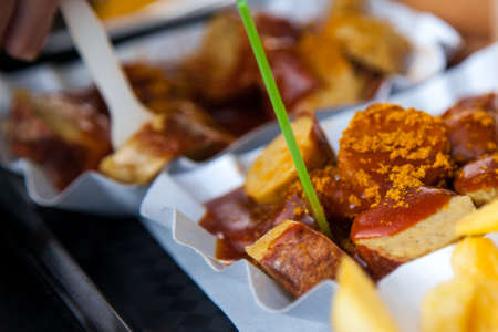 German Currywurst sausage with curry sauce, french fries and mayonnaise on food marketの写真素材