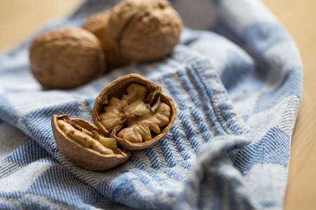 Cracked walnut, nutshell and nutcracker on kitchen towelの写真素材