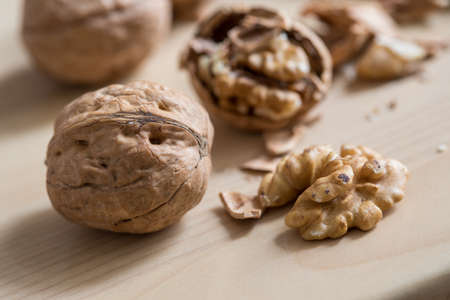 Cracked walnut, nutshell and nutcracker on wooden domestic kitchen countertopの写真素材