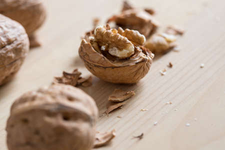 Cracked walnut, nutshell and nutcracker on wooden domestic kitchen countertopの写真素材