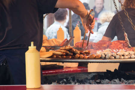 Swing BBQ barbeque barbecue food stall with pork neck steaks, German Bratwurst and Krakauer sausages...