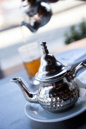 Moroccan mint tea with glass and teapot in Marrakech cafの写真素材