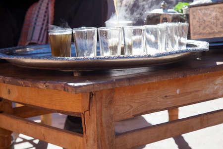 Man at preparation of Moroccan mint tea ceremony with glass and teapot in Marrakech Moroccoの写真素材