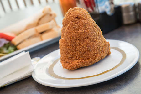 Traditional Sicilian arancini with rice and bolognese in street cafeの写真素材