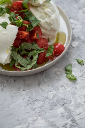 Buffalo mozzarella cheese ball with cocktail tomatoes, basil, olive oil and white balsamic vinegar...