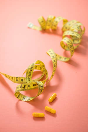 Diet vitamin pills and measure tapeの写真素材