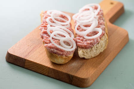 Typical German raw ground pork meat with onions on bread rollsの写真素材
