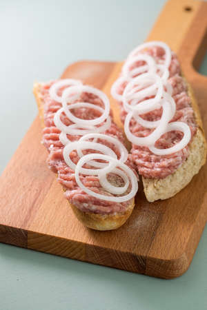 Typical German raw ground pork meat with onions on bread rollsの写真素材