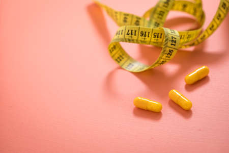 Diet vitamin pills and measure tapeの写真素材