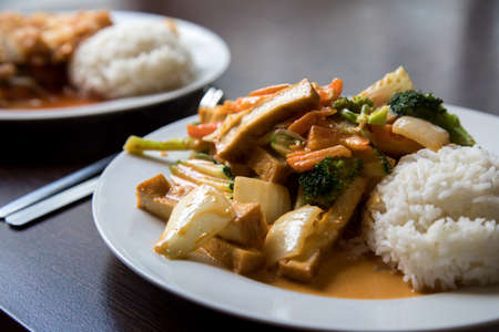 Asian dishes with curry tofu and chicken during lunch breakの写真素材