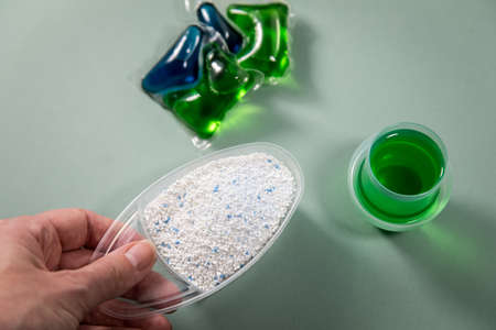 Woman choosing from laundry detergent variety of powder, liquid gel and pod for washing clothesの写真素材